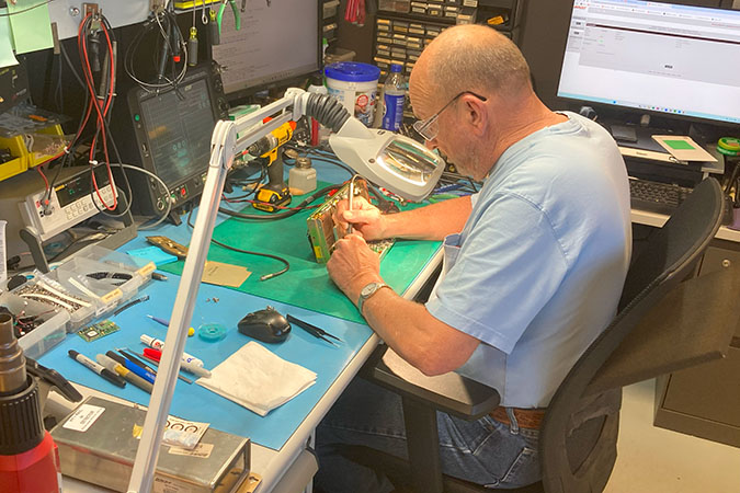 Robert Peterson, electronic technician II, tests a circuit board. 
