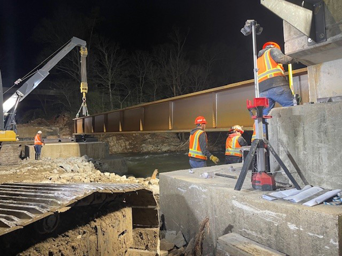 Crews install a bridge span at 3:30 a.m. on April 9.