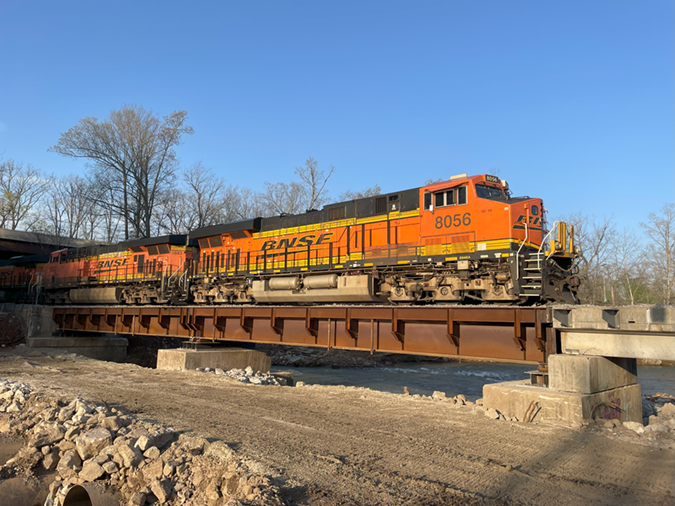 The first train crosses a newly built rail bridge in Mammoth Spring, Arkansas, just five days after the previous bridge was washed away by flooding.