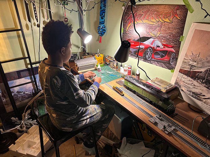 Daecian working on a model railroad layout. 