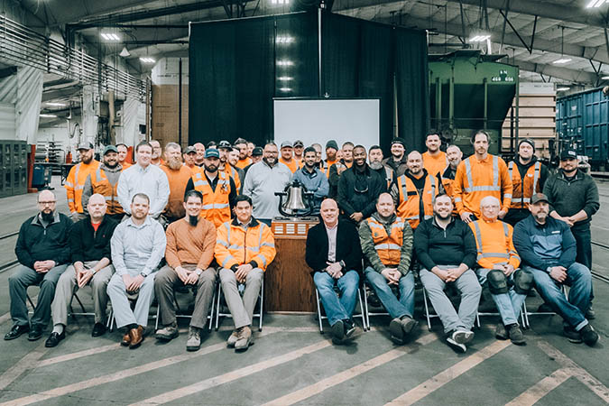 Members of the Twin Cities Division Mechanical team gather around the Safety Bell they&rsquo;ve just been awarded at BNSF&rsquo;s Northtown Yard in Minneapolis, Minnesota. 