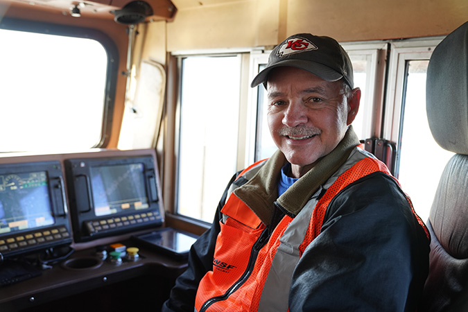 Brett in the engineer&rsquo;s seat of a locomotive.